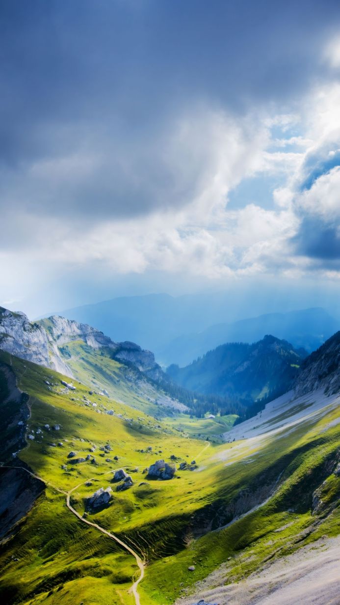 Mountain range with green valley under a cloudy sky