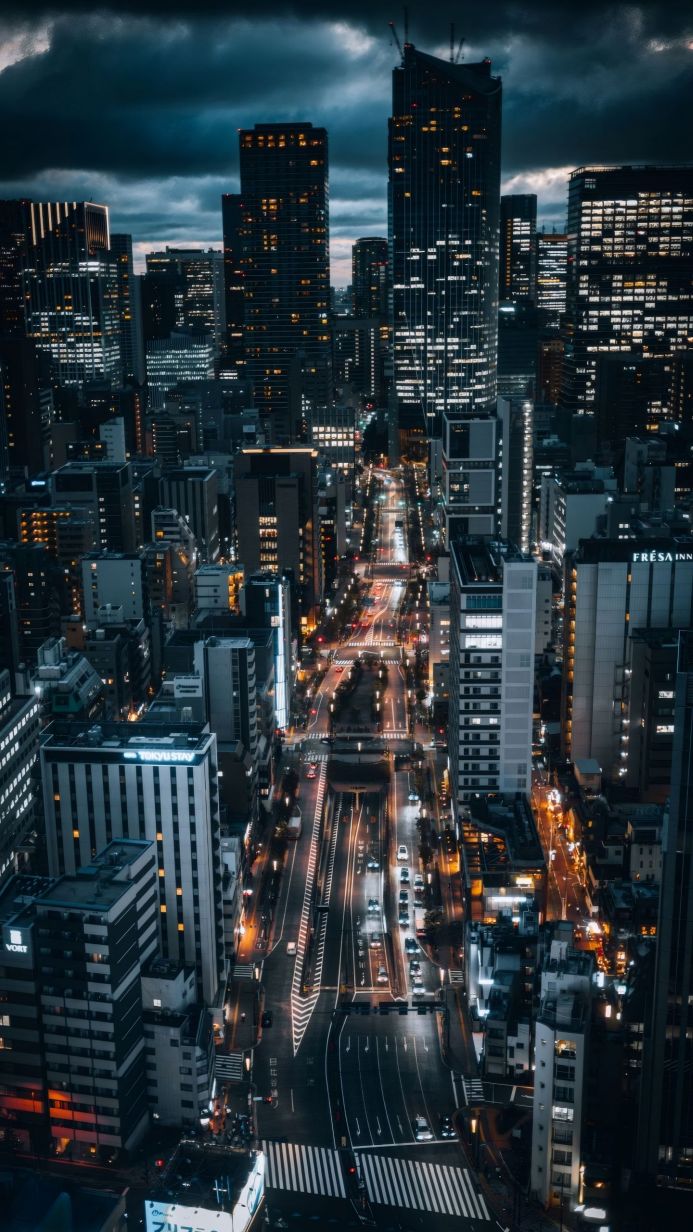 Cityscape at night with illuminated buildings and cars on the street