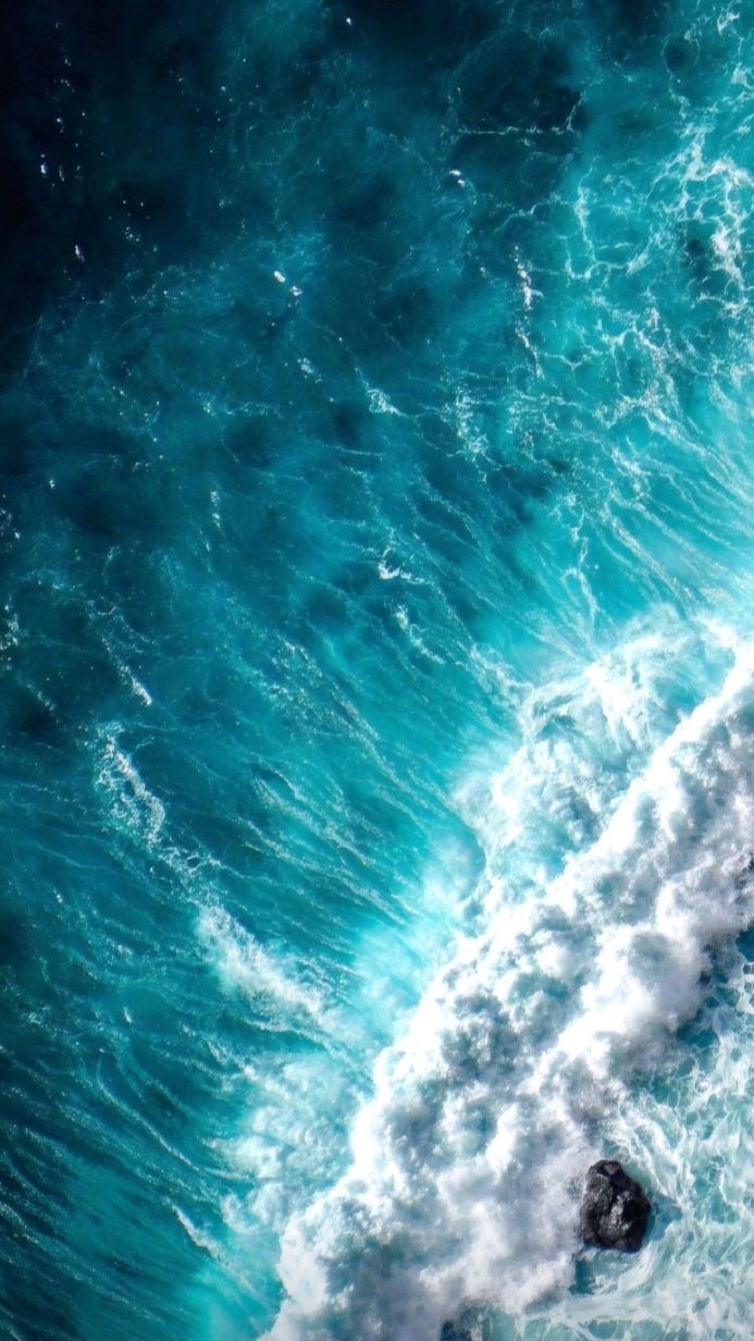 Aerial view of ocean waves with turquoise water and white foam