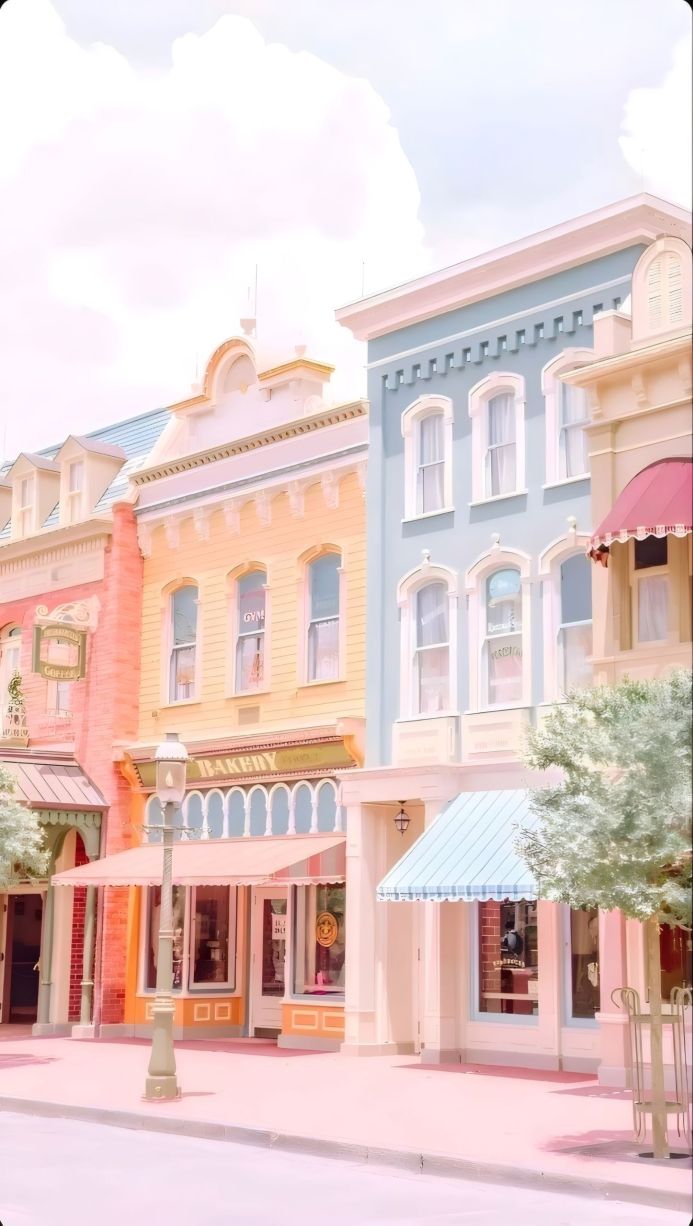 Pastel colored buildings on a street with storefronts and a streetlight