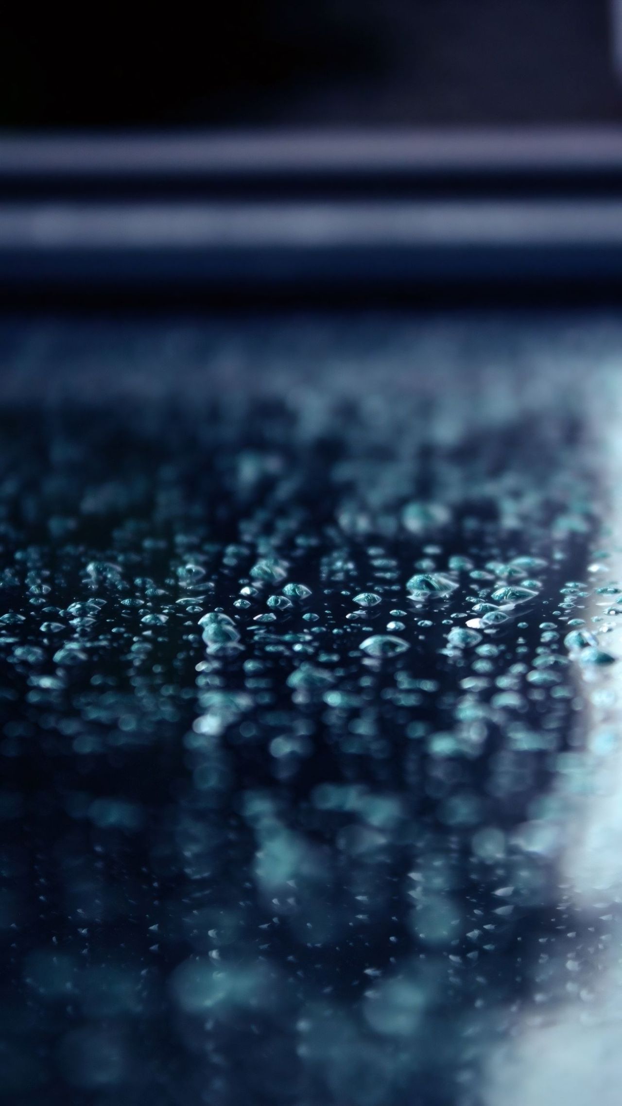 Water droplets on dark surface with bokeh effect