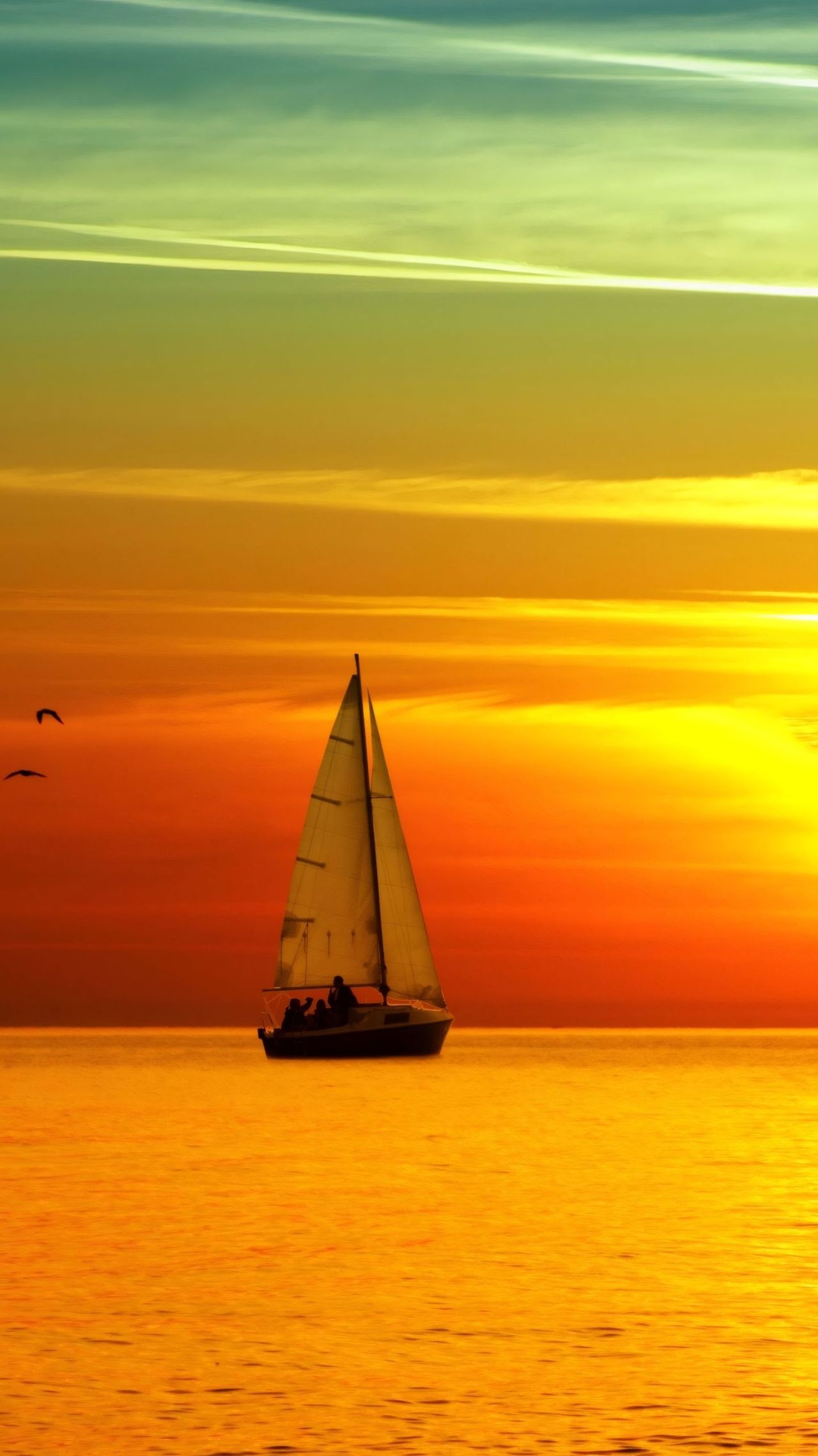 Sailboat on water at sunset with colorful sky