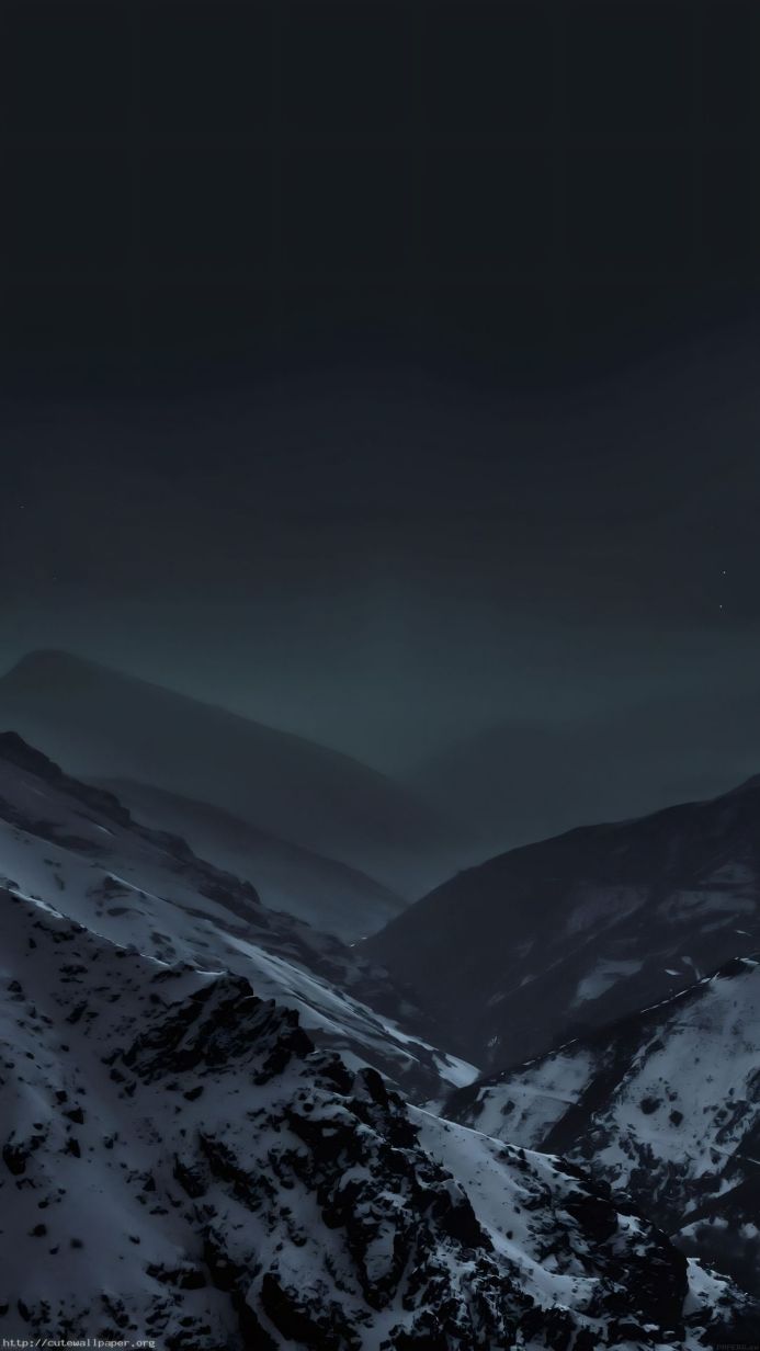 A snow-covered mountain range under a dark sky