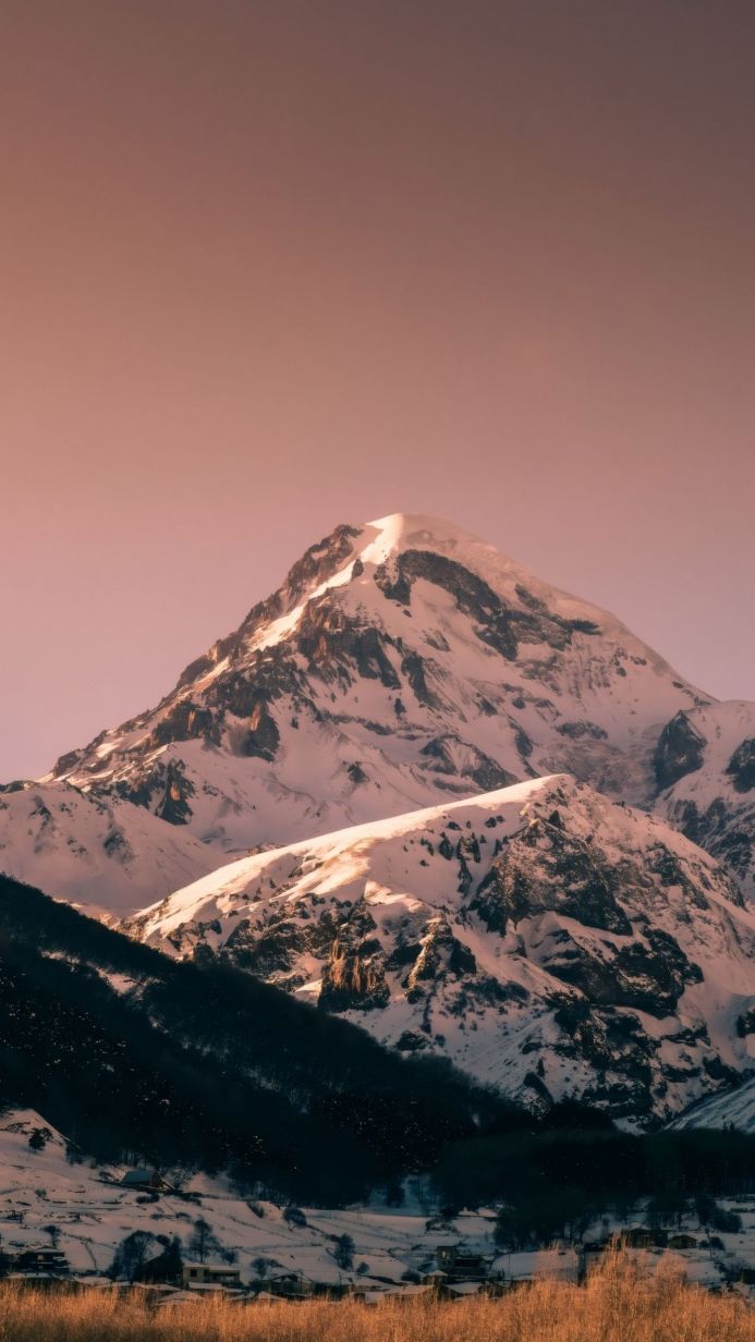 Snow-covered mountain peak with sunlight on the snow