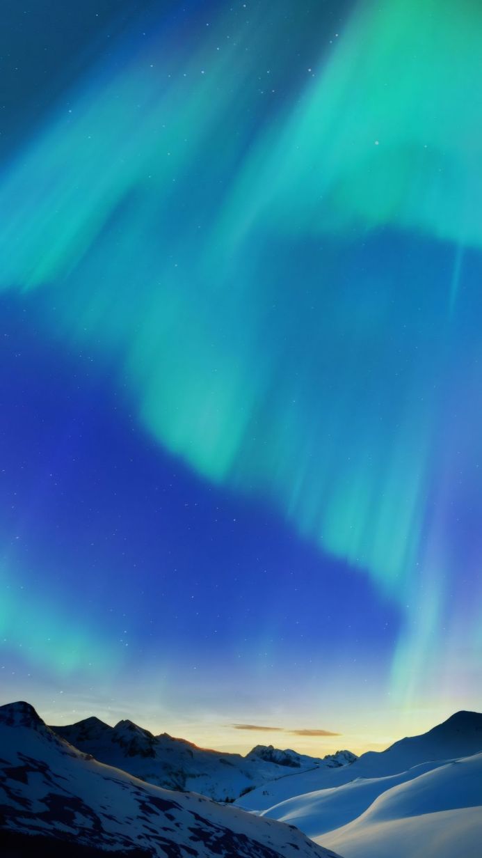 Snowy mountains under a vibrant aurora borealis with a starry sky