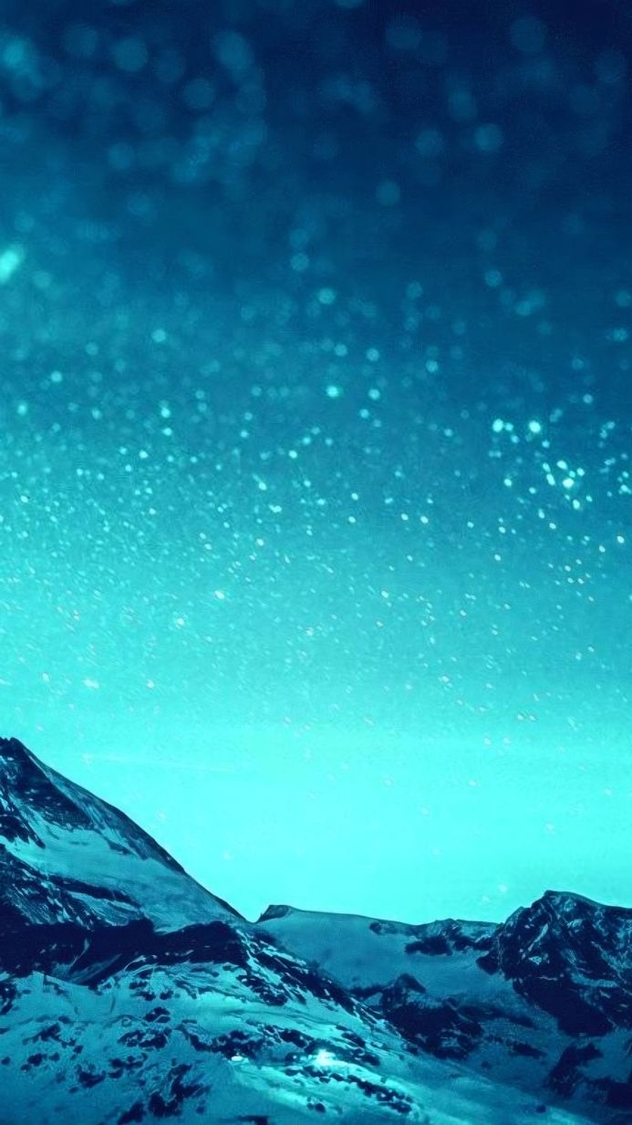 Snowy mountains against a blue sky with bokeh lights