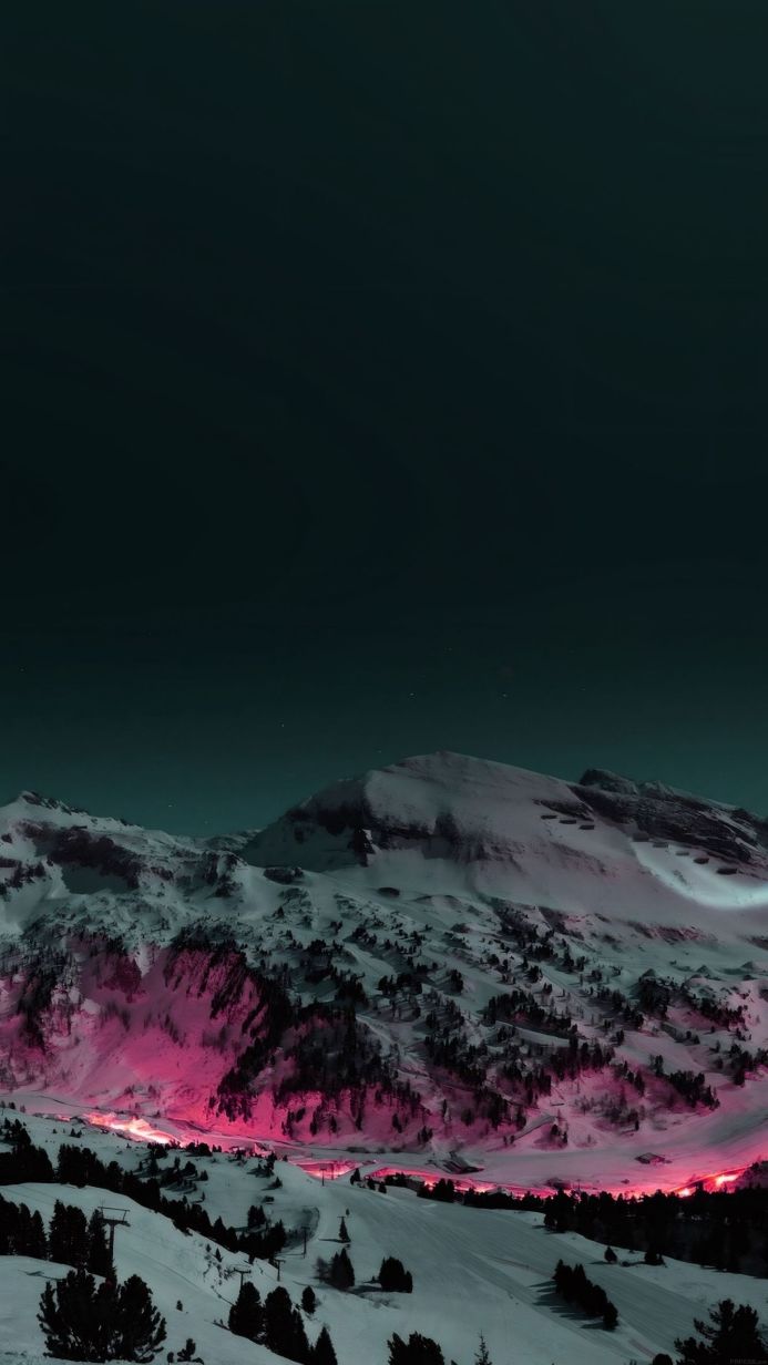 Snowy mountains with pink glow at night