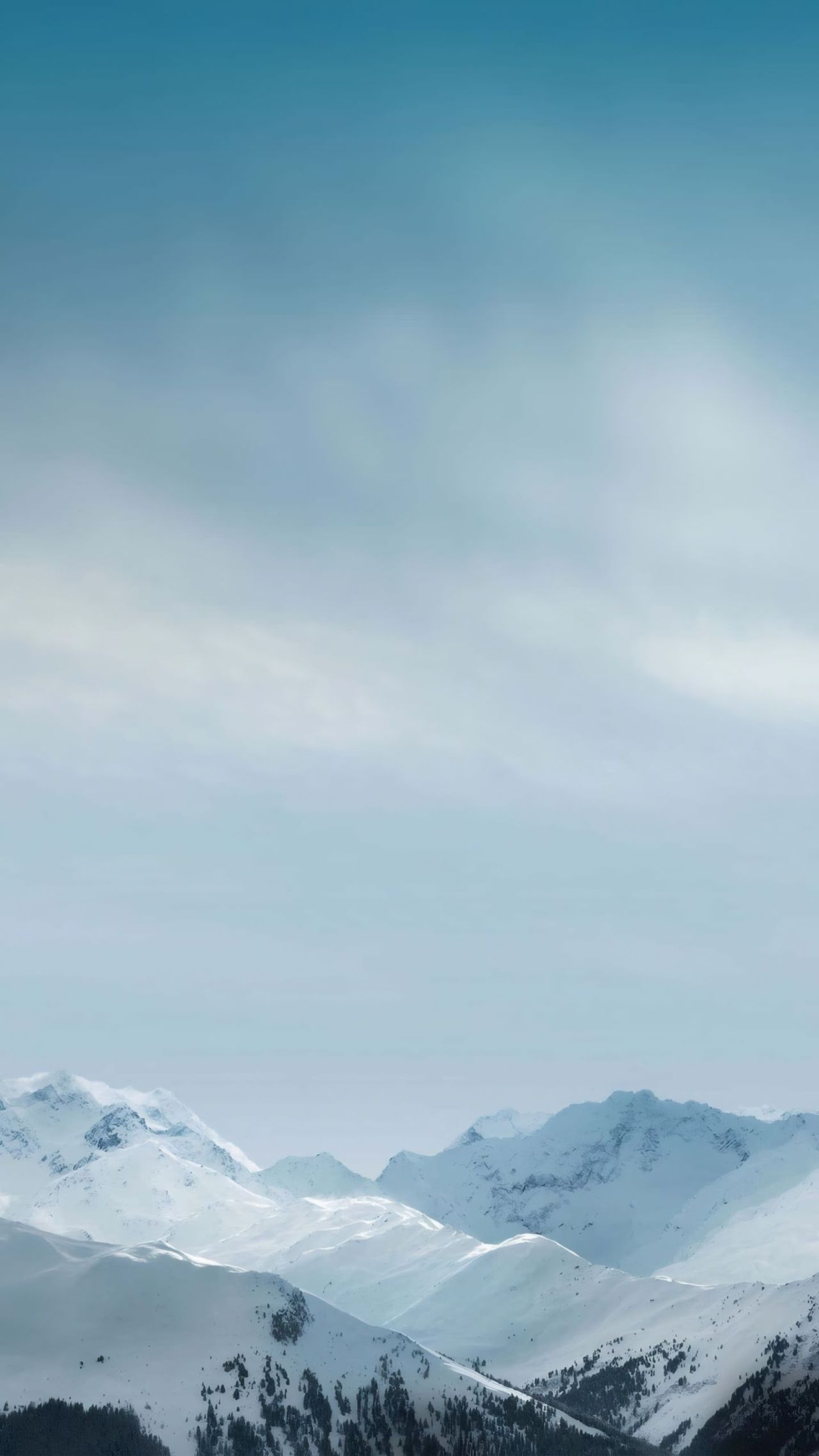 Snowy mountain peaks under pale blue sky
