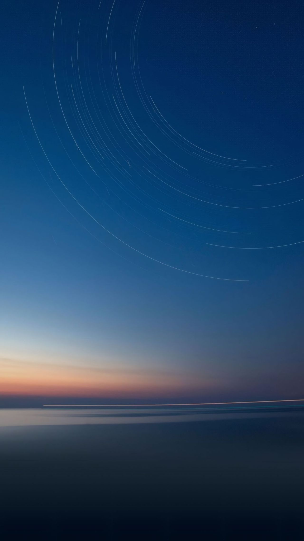 Star trails over water at twilight