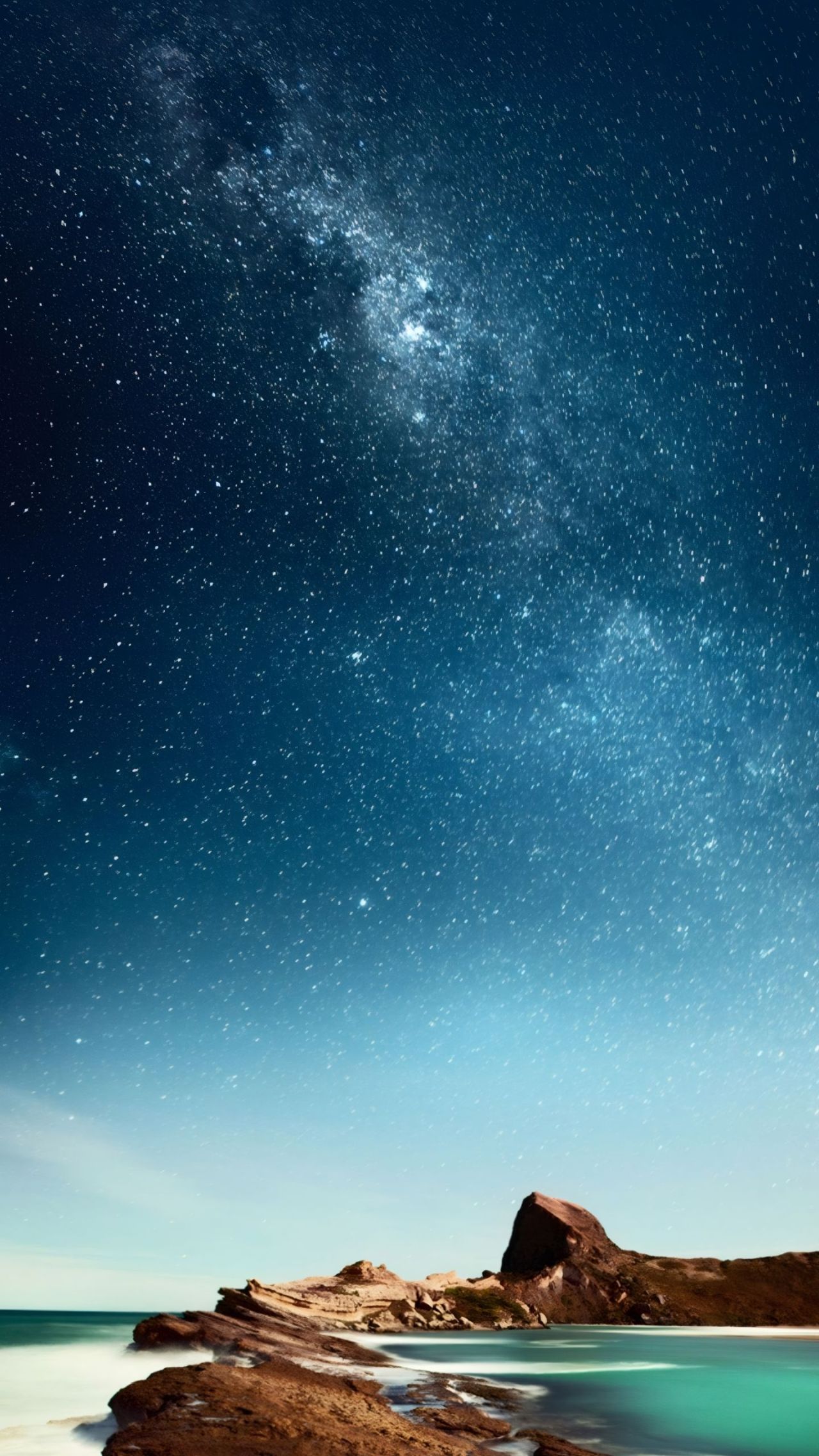 Starry sky over rocky coast landscape