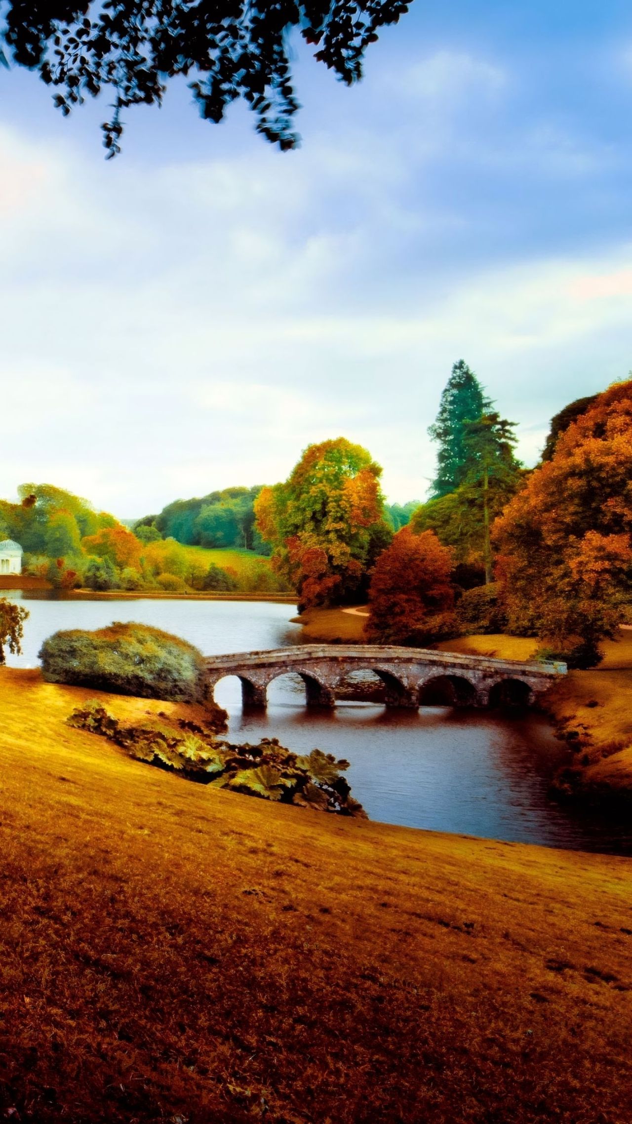 Autumn landscape with stone bridge over water
