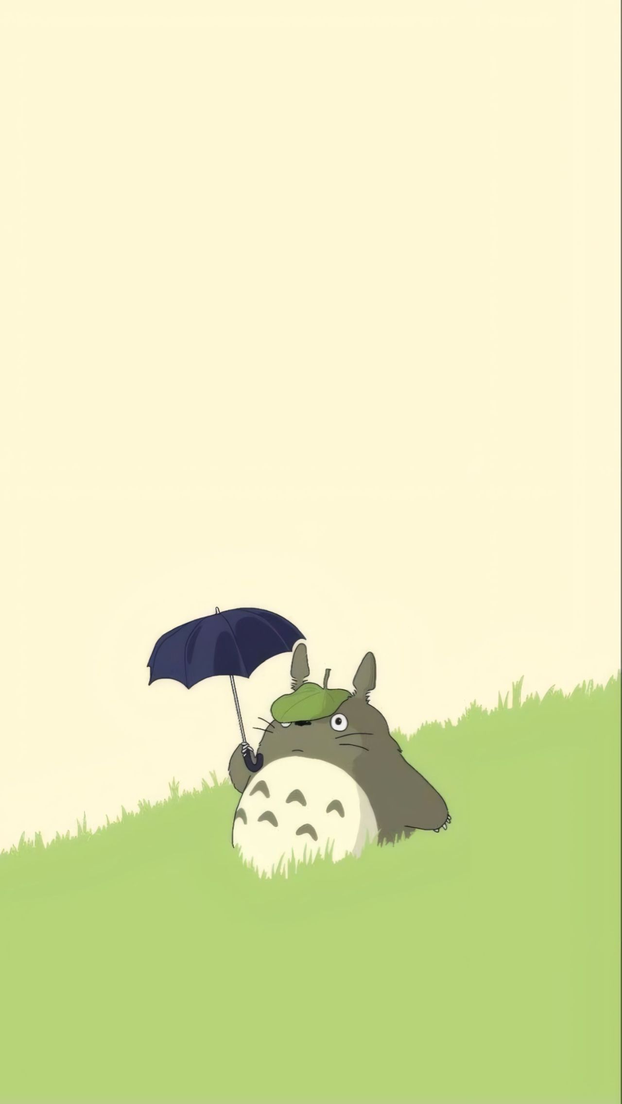 Totoro holding umbrella in a field
