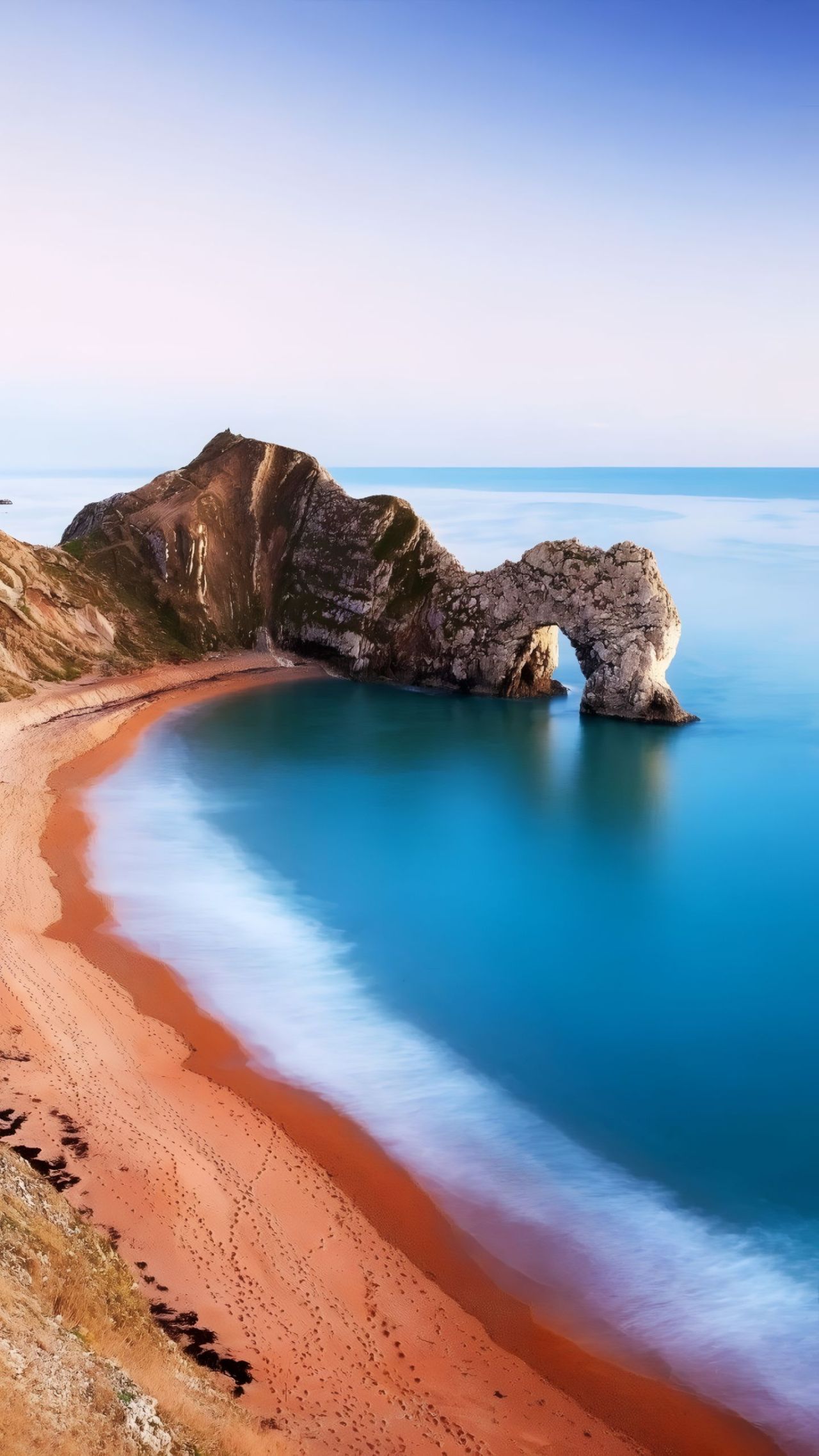 Durdle Door natural arch rock formation on a beach