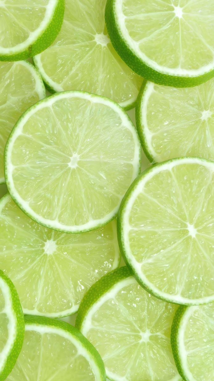 Close-up of many lime slices, vibrant green