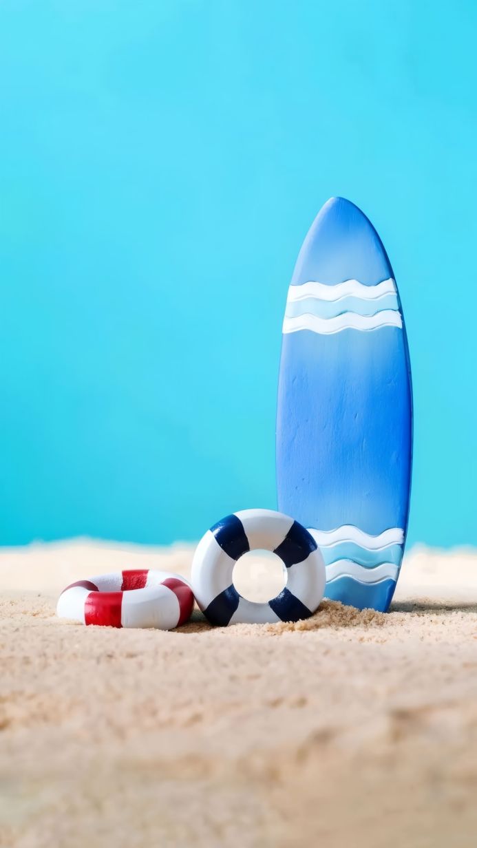Surfboard and lifebuoys on a sandy beach against a blue background
