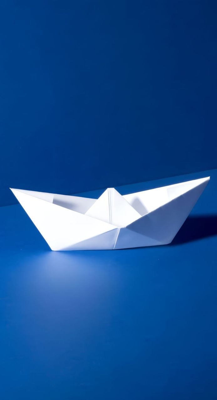 White paper boat on a blue background