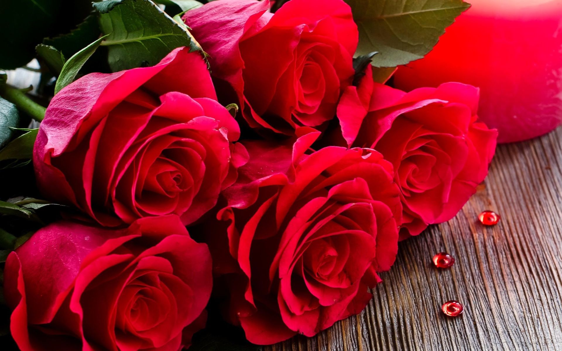 bouquet of red roses on a wooden surface